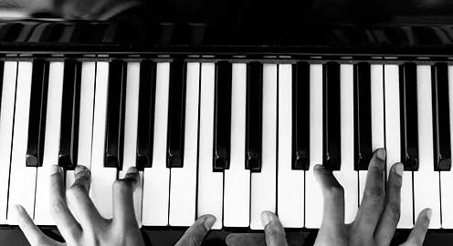 Hands playing a chord in a Piano